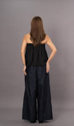 Woman wearing a black strapless tube top and wide-leg denim trousers pants