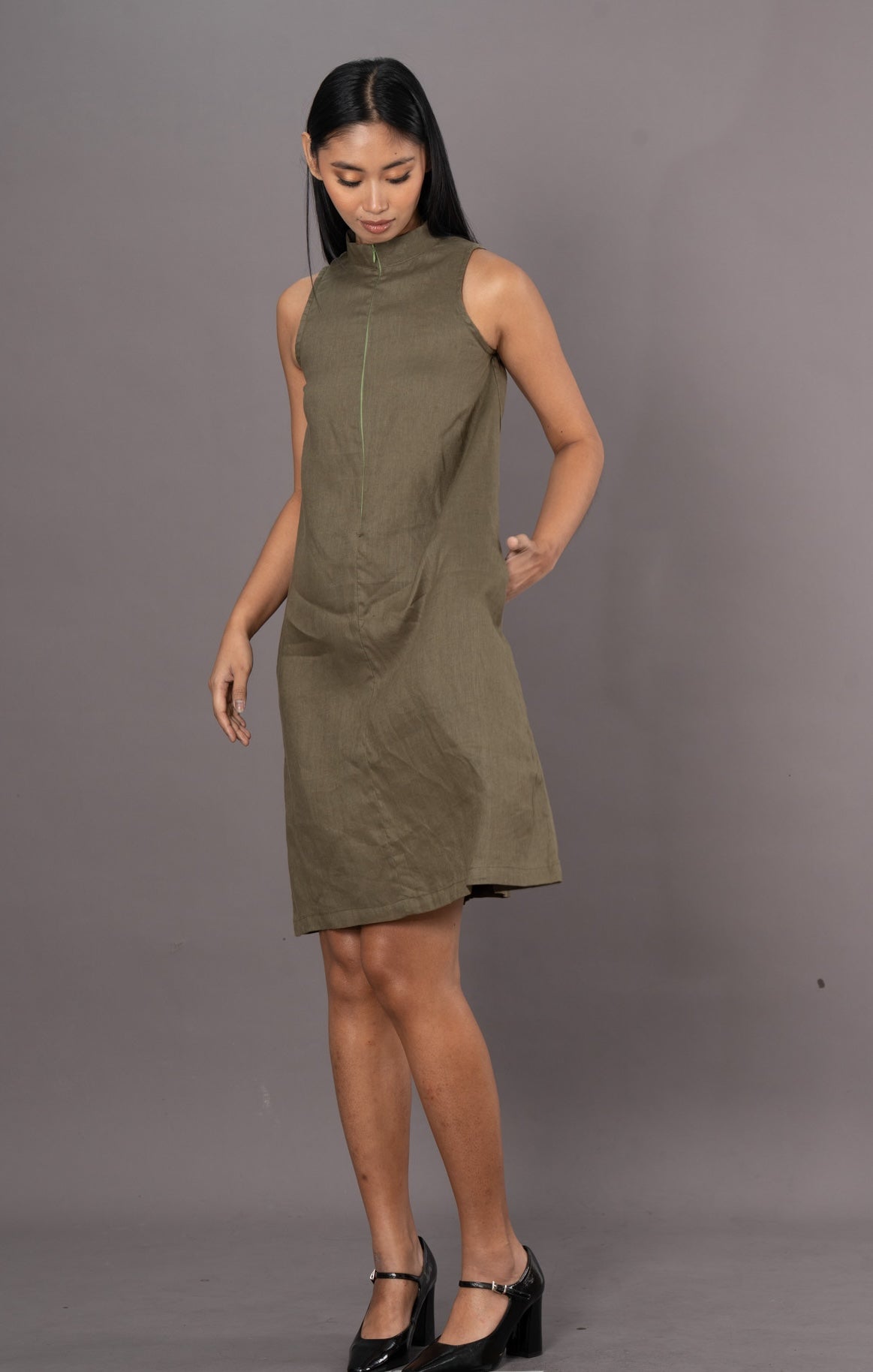 Woman wearing an olive green sleeveless A-line dress