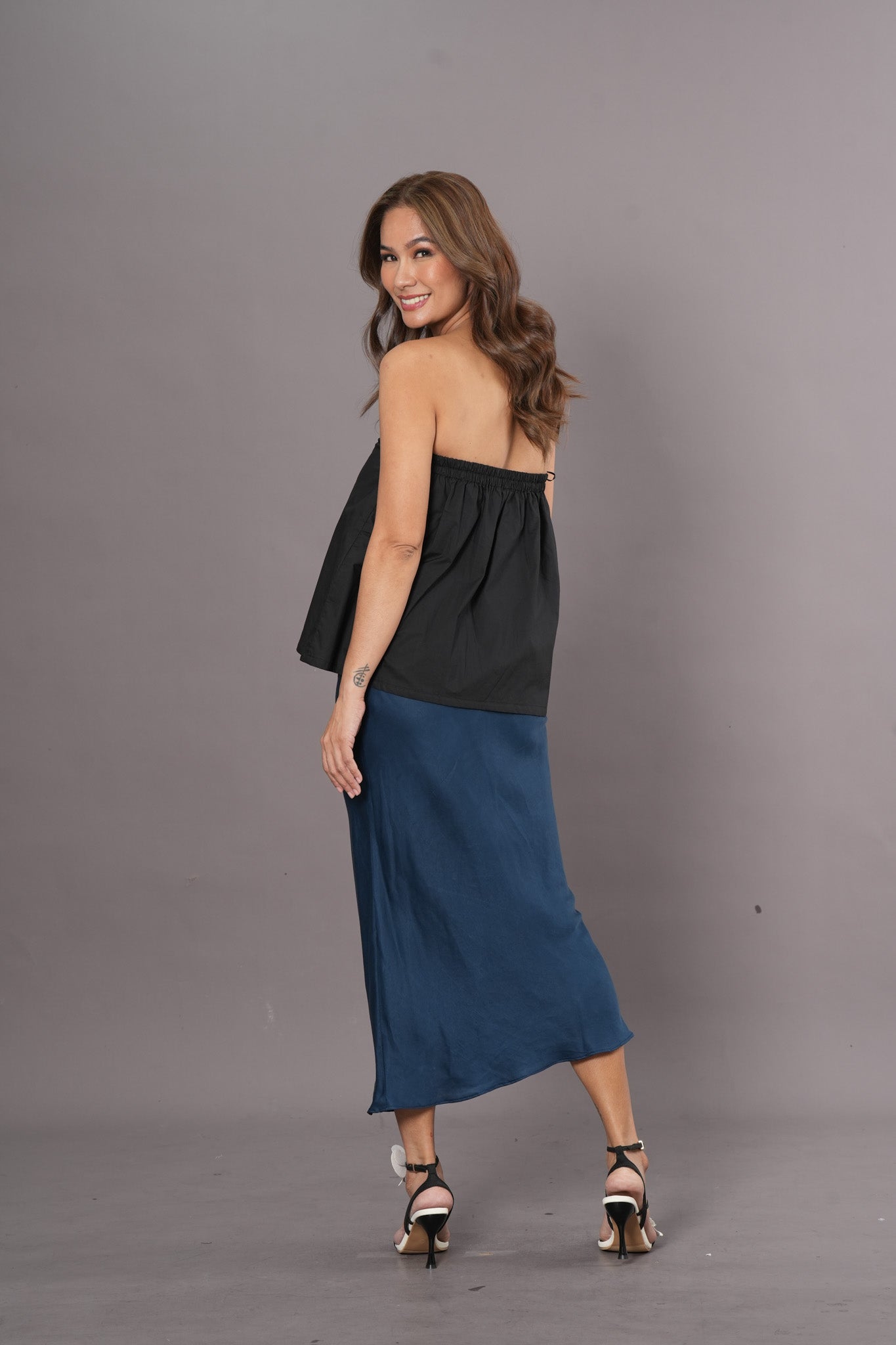 Woman wearing a black tube top and long blue fluid Tencel skirt