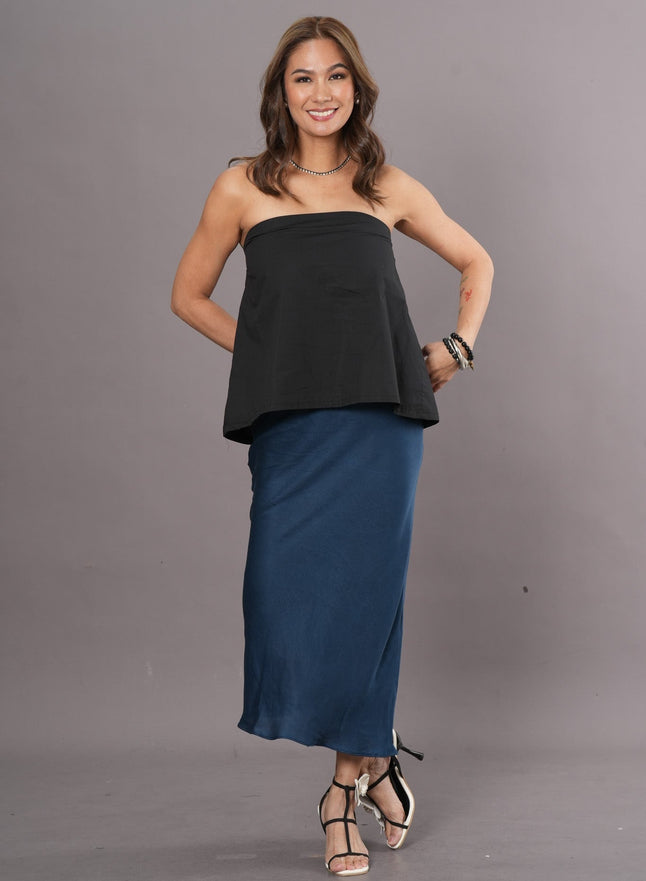 Woman wearing a black tube top and long blue fluid Tencel skirt