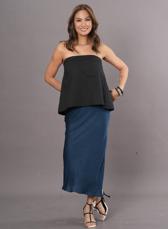 Woman wearing a black tube top and long blue fluid Tencel skirt
